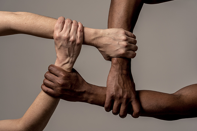 Manos de diferentes personas de diferentes razas unidas y enlazadas