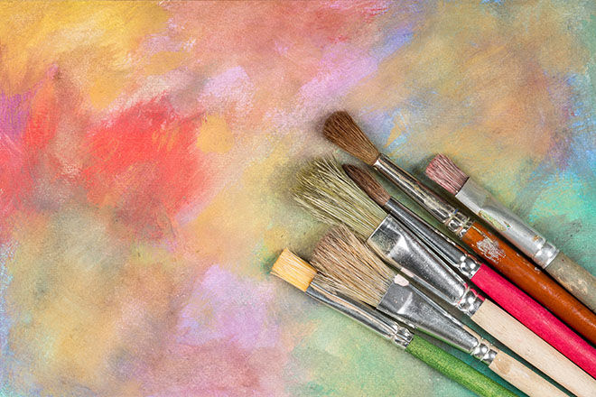 Pinceles de diferentes formatos sobre un fondo de colores difuminado
