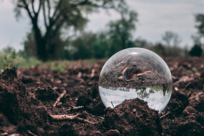 Esfera de cristal sobre tierra húmeda