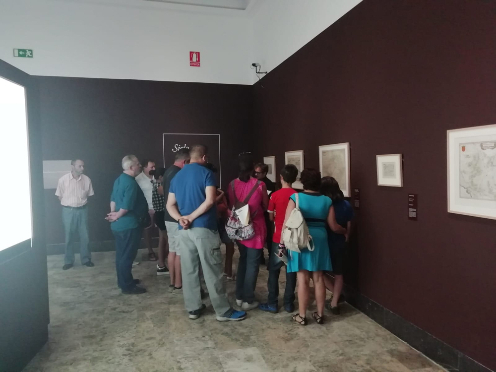 Grupo de visitantes atendiendo las explicaciones de uno de los guías de la exposición