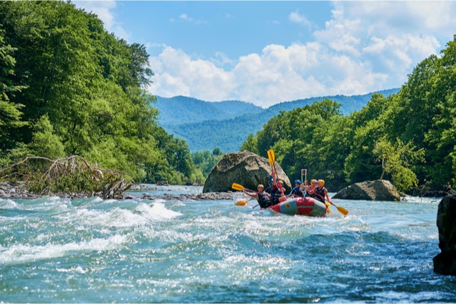 Gente en una barca haciendo rafting en un rio