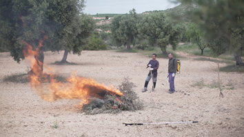 Dos personas haciendo un fuego controlado
