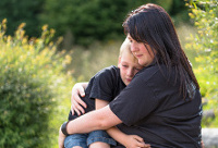 Mujer adulta sentada con niño entre sus brazos