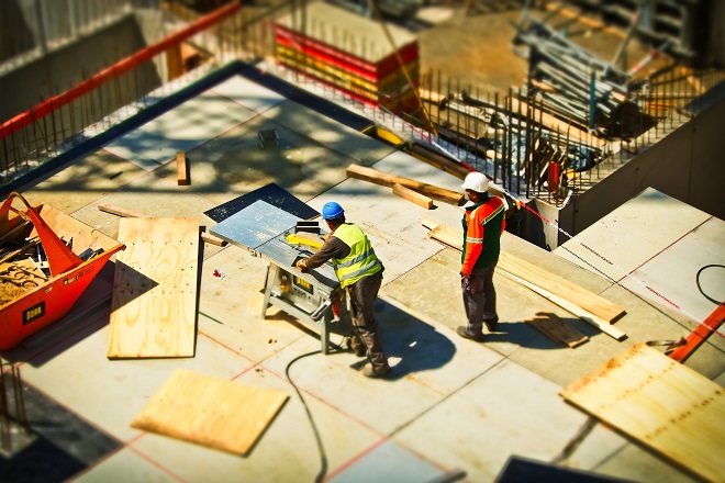 Imagen de dos obreros trabajando en la construcción de un edificio.