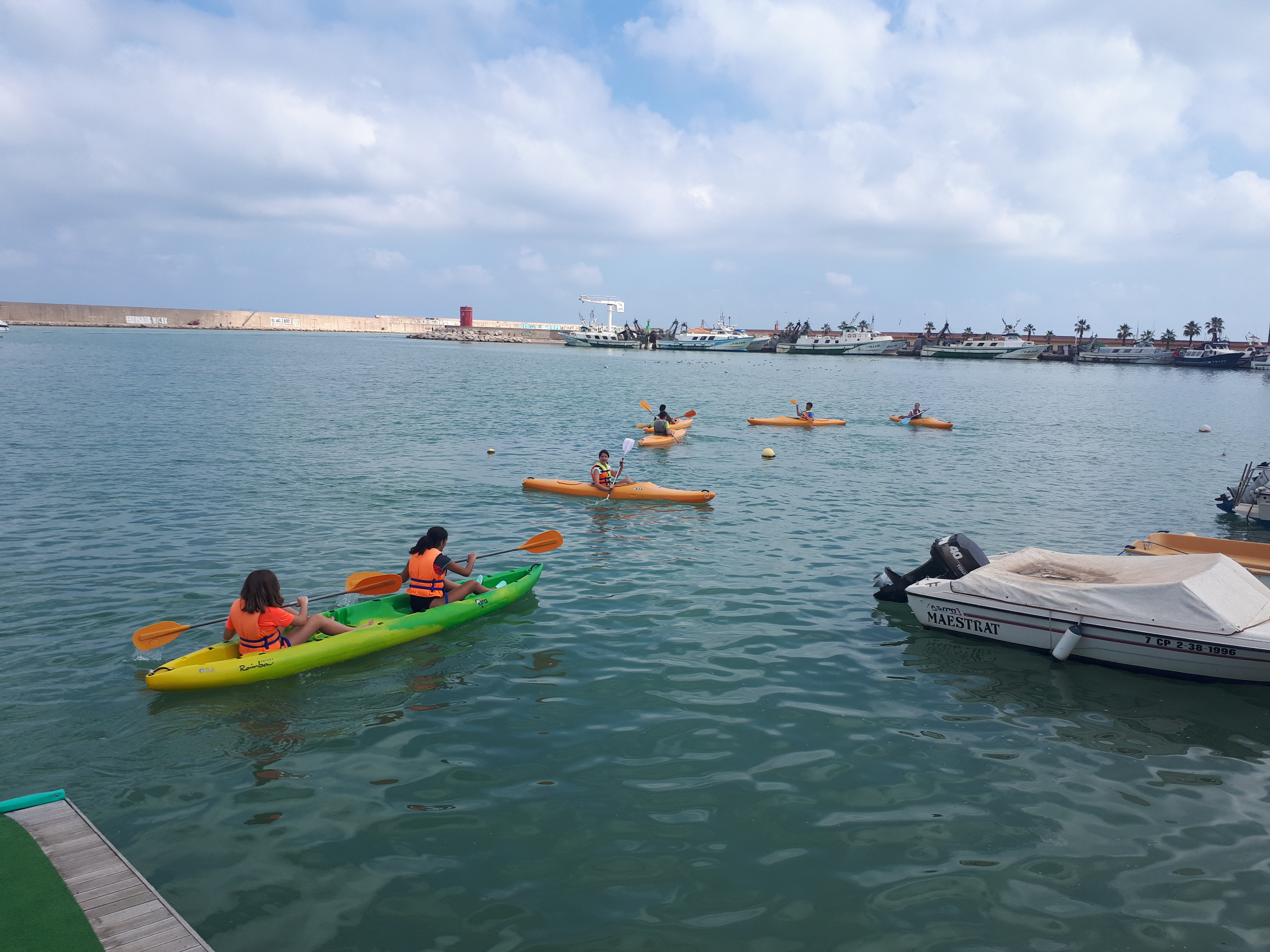Grupo de chicos en una actividad naútica con canoas.