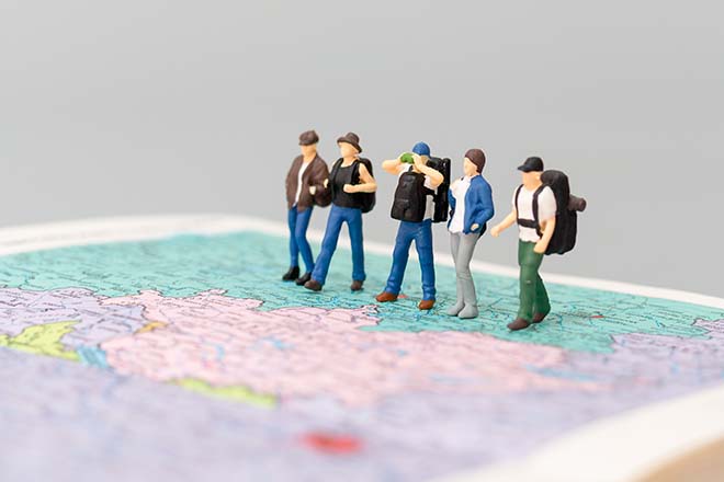 Sobre el dibujo de un mapa hay un grupo de montañeros.