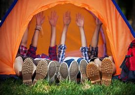 Grupo de jóvenes tumbados en una tienda de campaña de la que sobresalen los pies.