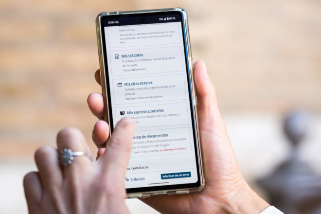 Manos de una persona en primer plano consultado un teléfono móvil