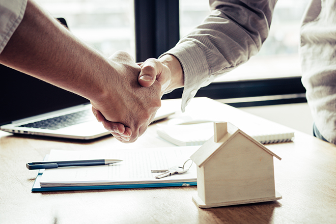 Manos se entrelazan tras la firma de hipoteca de vivienda