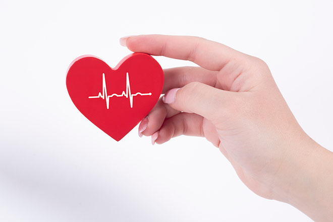 Mano sujetando corazón de fieltro con dibujo en su interioir
