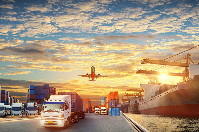 Camiones, barco y avión que transportan mercancías en el horizonte 