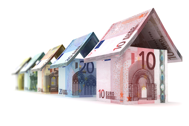 Fotografía de varias casitas hechas con billetes de 10, 20 ... € a modo de castillos de naipes.