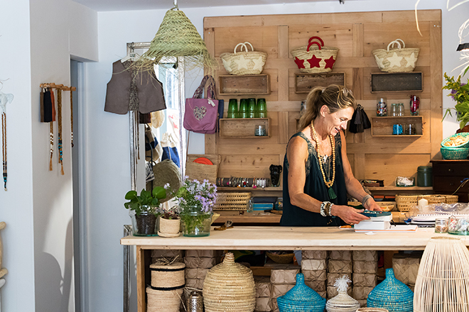 Mujer emprendedora trabajando feliz en su tienda de artesanía y decoración