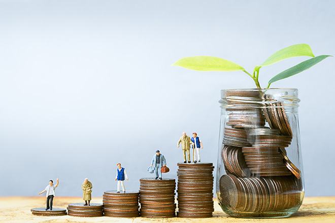 Gente en miniatura de pie sobre monedas