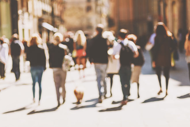 Personas andando por una calle, en un fondo difuminado