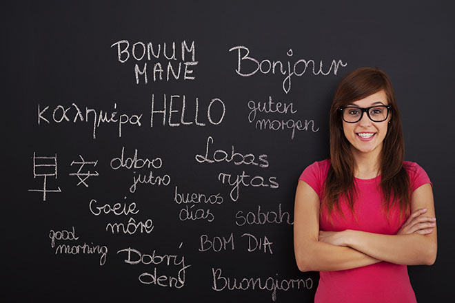 Alumna delante de pizarra con palabras en distintos idiomas