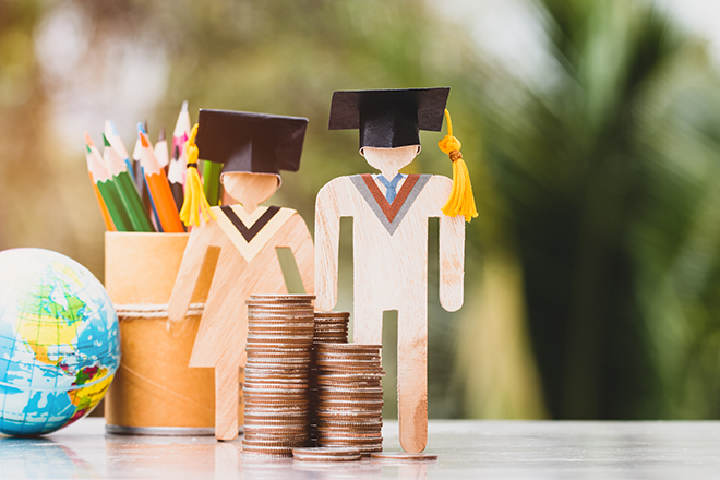 Muñecos representando estudiantes, acompañados de monedas y útiles de estudio