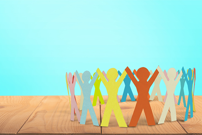 Figuras planas de colores que representan a personas formando un círculo y con las manos entrelazadas en alto