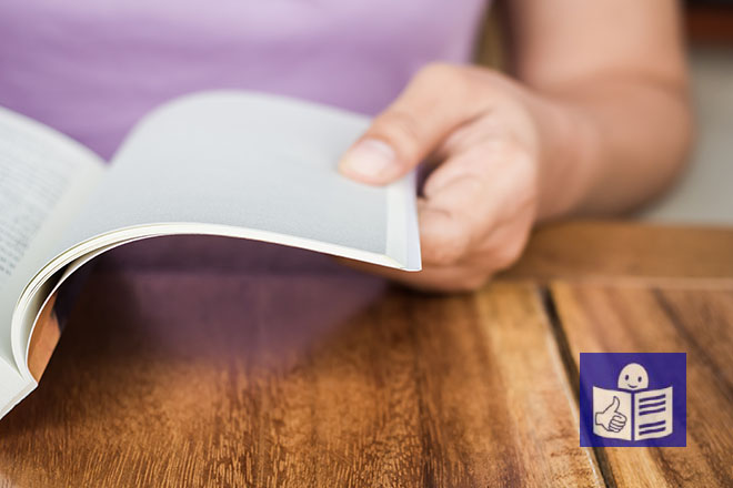 Detalle de un libro abierto y una mujer leyéndolo (la fotografía incluye el icono de lectura fácil en el margen inferior derecha)